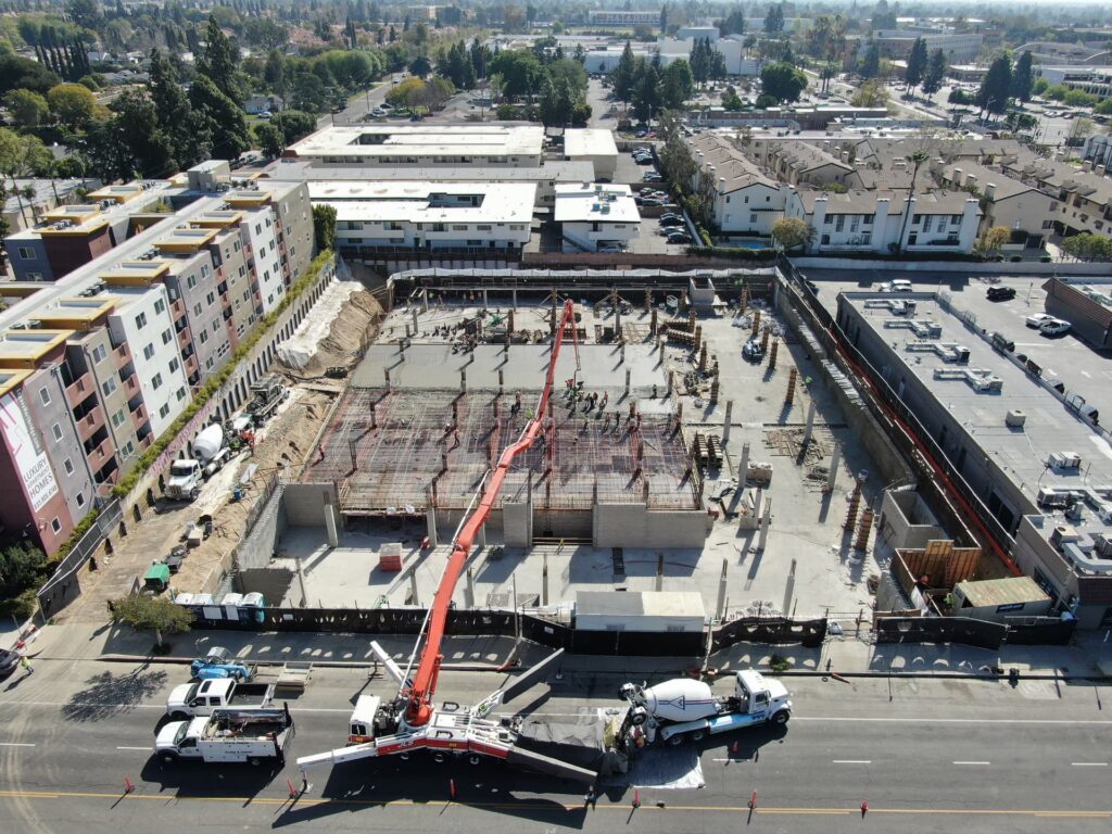 Large concrete foundation pour with pump boom and active jobsite crews