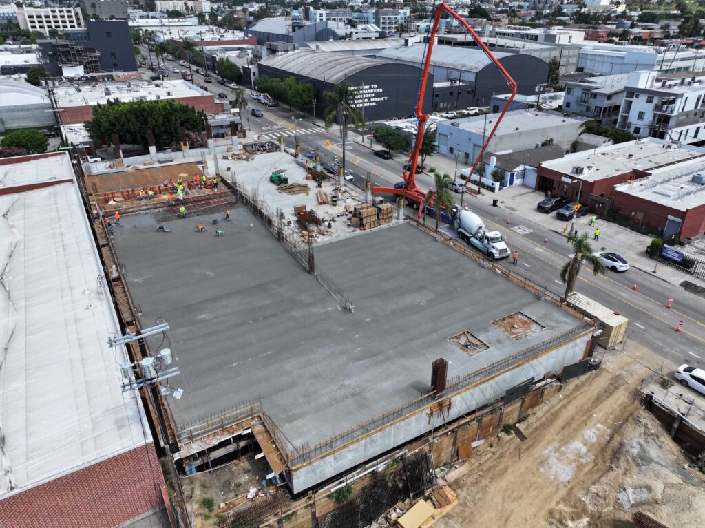 Wide aerial view of freshly poured concrete slab on commercial project
