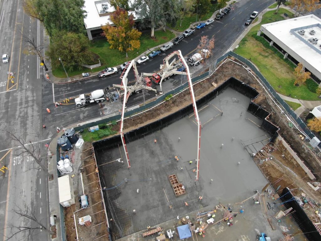 Aerial view of large concrete foundation pour with dual pump trucks
