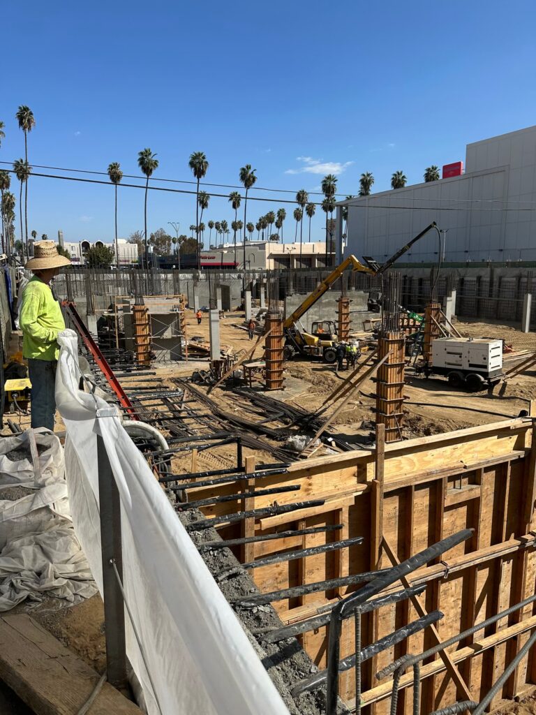 Concrete foundation formwork and rebar installation at active commercial construction site