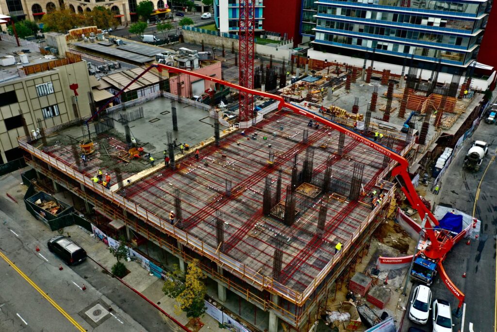 Concrete slab and column construction with pump truck placing fresh concrete
