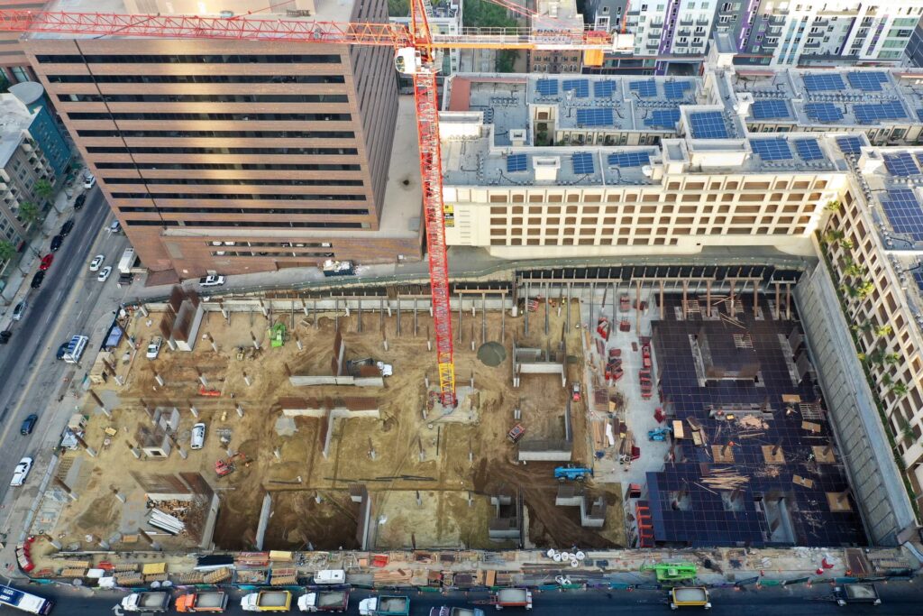 Urban foundation construction with tower crane, rebar, and concrete operations